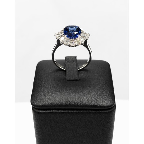 103 - AN 18CT WHITE GOLD OVAL SAPPHIRE AND DIAMOND CLUSTER RING, the central sapphire of 2.83 carats, surr... 