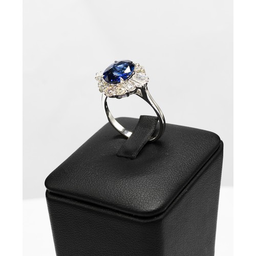 103 - AN 18CT WHITE GOLD OVAL SAPPHIRE AND DIAMOND CLUSTER RING, the central sapphire of 2.83 carats, surr... 