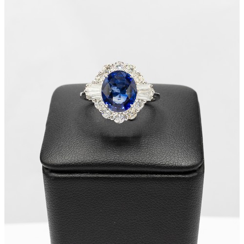 103 - AN 18CT WHITE GOLD OVAL SAPPHIRE AND DIAMOND CLUSTER RING, the central sapphire of 2.83 carats, surr... 