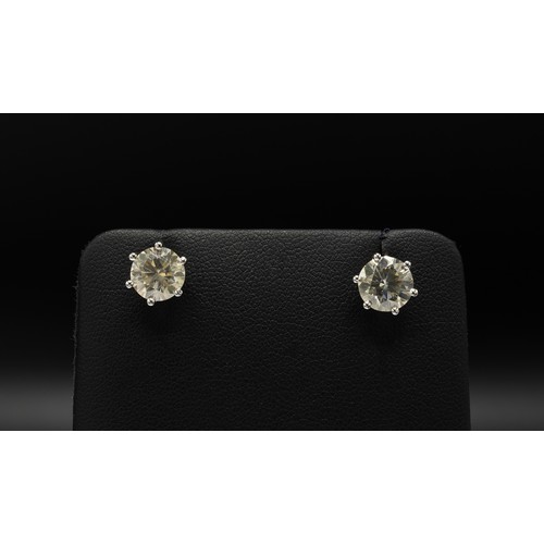 105 - A PAIR OF 18CT WHITE GOLD DIAMOND SOLITAIRE STUD EARRINGS, each with a claw set round brilliant cut ... 