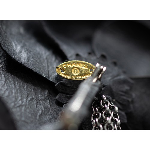 25A - CHANEL BROOCH, iconic camellia flower in black distressed calfskin leather and gun metal tone accent... 