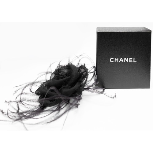 46 - CHANEL BROOCH, iconic black silk camellia with raw hem, ostrich feather at base, gold tone safety pi... 