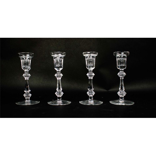 91 - A WATERFORD SET OF FOUR CANDLESTICKS, facetted stems, circular bases, each measuring 21cm high. (4)