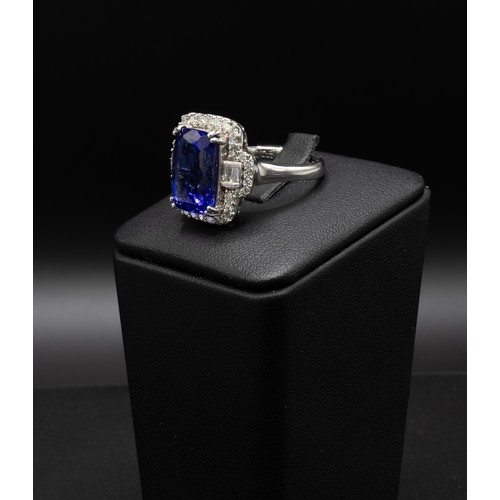 111 - AN 18CT WHITE GOLD TANZANITE AND DIAMOND DRESS RING, the central rectangular tanzanite surrounded by... 