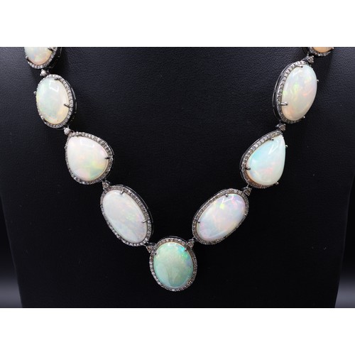 114 - A LARGE OPAL AND STERLING SILVER NECKLACE, set with opal cabochons, each surrounded by round cut dia... 