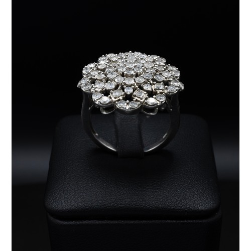 116 - A DIAMOND CLUSTER COCKTAIL RING, with an intertwined design of approximately 61 round brilliant cut ... 