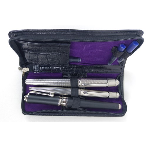 120A - TWO CARTIER BALLPOINT WHITE METAL PENS, comprising one with an engine turned case, blue cabochon ter... 