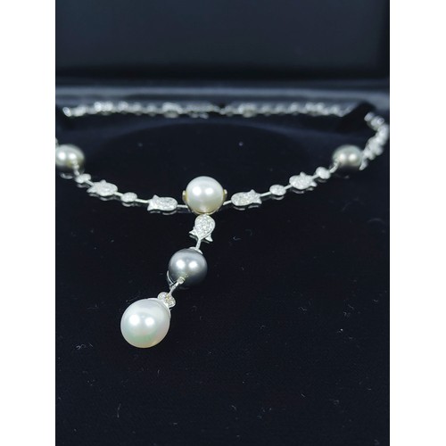 130A - A DIAMOND ENCRUSTED WHITE METAL AND PEARL NECKLACE, possibly 18ct white gold, with white and Tahitia... 