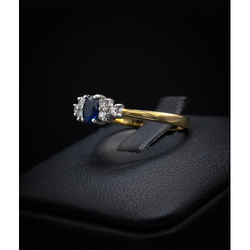 137 - AN 18CT YELLOW GOLD SAPPHIRE AND DIAMOND DRESS RING, the central oval mixed cut sapphire flanked by ... 