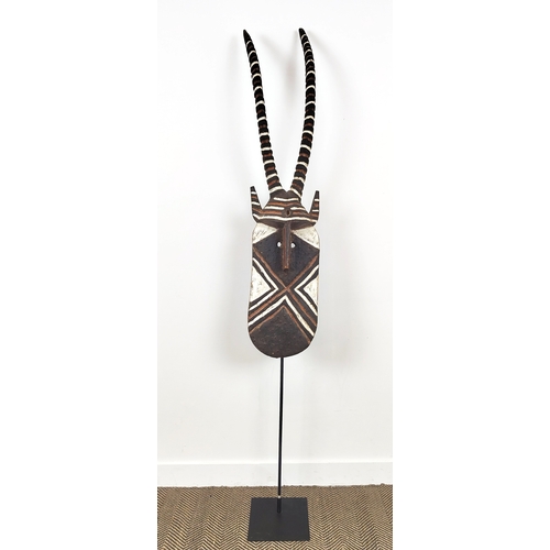 10 - AFRICAN MASK, carved wood on a metal floor stand, overall 203cm tall.