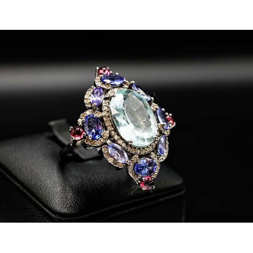 26 - LARGE DRESS RING IN WHITE METAL SET, with a central oval aquamarine, diamonds, tanzanites and tourma... 