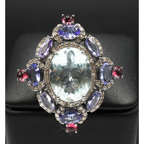 26 - LARGE DRESS RING IN WHITE METAL SET, with a central oval aquamarine, diamonds, tanzanites and tourma... 