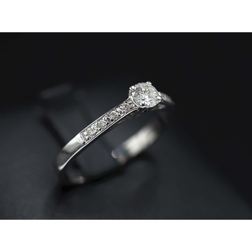 17 - 18CT WHITE GOLD SOLITAIRE-STYLE DIAMOND RING, with further diamonds set to the shoulders, RBC diamon... 