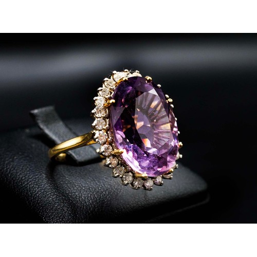 25 - 18CT YELLOW AND WHITE GOLD RING MULTI-CLAW SET, with a large oval amethyst surrounded by RBC diamond... 