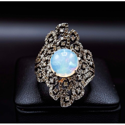 28 - LARGE DRESS RING IN SILVER SET, with a central round cabochon opal and diamond set filigree surround... 