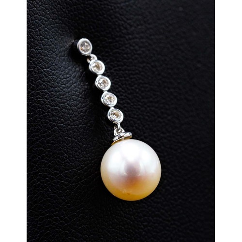 64A - A PAIR OF 9CT WHITE GOLD CULTURED PEARL DROP EARRINGS, each with diamond set bales, diamonds with a ... 