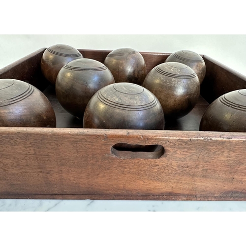 140 - BOWLS, a set of eight, vintage lignum vitae bowls in an old mahogany tray, tray 51cm x 46cm x 12cm.