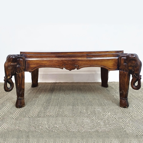 171 - LOW TABLE, rectangular hardwood on carved elephant supports, 43cm H x 119cm x 70cm.