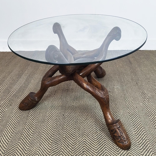 176 - LOW TABLE, circular glass top on shaped and carved hardwood supports, 50cm H x 100cm D.