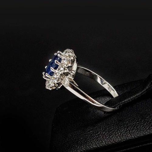 54 - PLATINUM RING SET WITH AN OVAL SAPPHIRE, a halo of RBC diamonds and diamond set shoulders, sapphire ... 