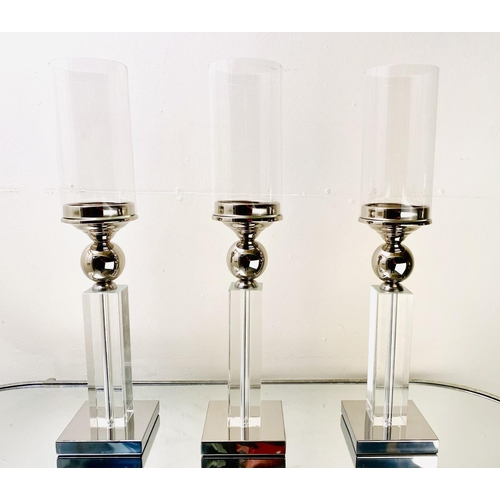 529 - CANDLESTICKS, a set of three, chrome and glass, 53cm H (3)