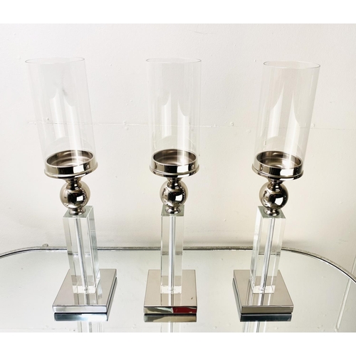 529 - CANDLESTICKS, a set of three, chrome and glass, 53cm H (3)