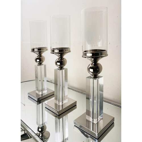 529 - CANDLESTICKS, a set of three, chrome and glass, 53cm H (3)