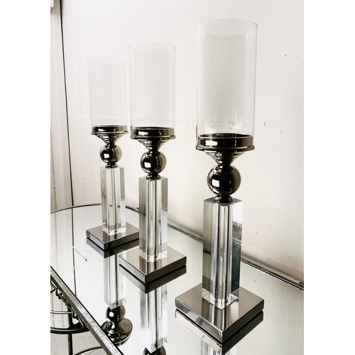 529 - CANDLESTICKS, a set of three, chrome and glass, 53cm H (3)