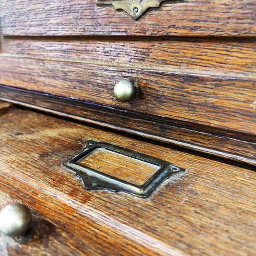 447 - HABERDASHERY CABINET, early 20th century French oak with twenty lift up doors, 213cm H x 95cm W x 38... 