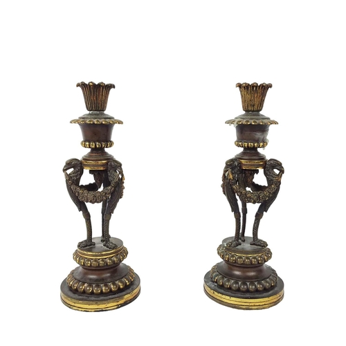 17 - CANDLESTICKS, a pair, 19th century French Empire, fashioned as braziers, triform eagle supports with... 