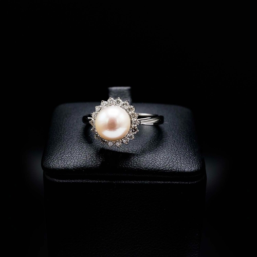 10 - A 9CT WHITE GOLD CULTURED PEARL AND DIAMOND HALO RING, boxed, the round brilliant cut diamonds of ap... 