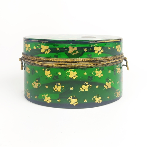 31 - BRISTOL EMERALD GLASS LIDDED CASKET, gold leaf motif decoration, oval form, twin handles, 10cm H.