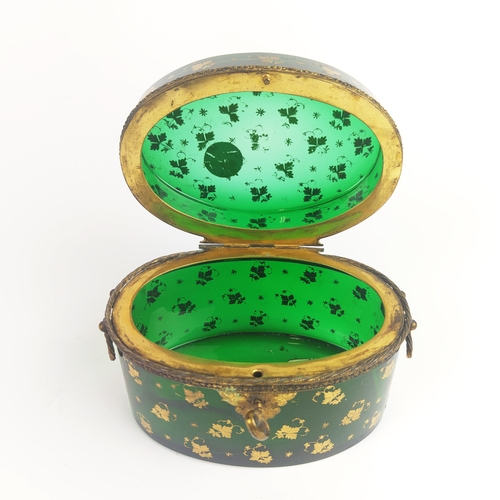 31 - BRISTOL EMERALD GLASS LIDDED CASKET, gold leaf motif decoration, oval form, twin handles, 10cm H.