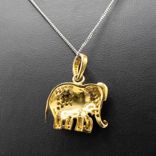 11 - AN ELEPHANT PENDANT IN YELLOW AND WHITE METAL SET WITH A RUBY EYE AND R/C DIAMONDS on a silver chain... 