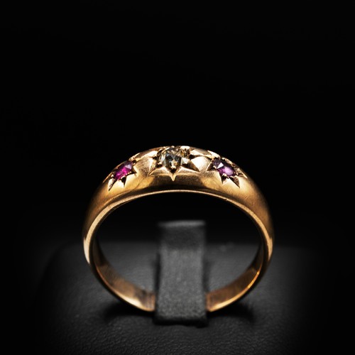 13 - A VINTAGE 9CT ROSE GOLD GYPSY RING SET with and old-cut fancy yellow diamond flanked by round cut ru... 