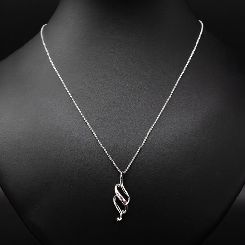 7 - A COLLECTION OF FOUR SILVER CHAINS including the following pendants: cross set with cubic zirconia, ... 