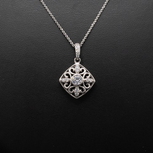 7 - A COLLECTION OF FOUR SILVER CHAINS including the following pendants: cross set with cubic zirconia, ... 