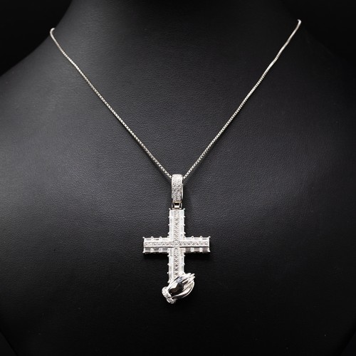 7 - A COLLECTION OF FOUR SILVER CHAINS including the following pendants: cross set with cubic zirconia, ... 