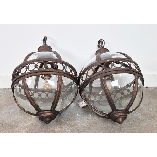 445 - A PAIR SPHERICAL HANGING LANTERN LIGHTS, with glazed bodies and pierced centres, 70cm H. (2)