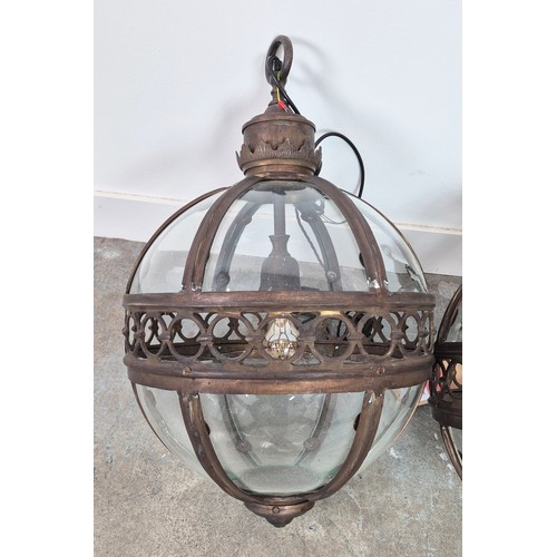 445 - A PAIR SPHERICAL HANGING LANTERN LIGHTS, with glazed bodies and pierced centres, 70cm H. (2)