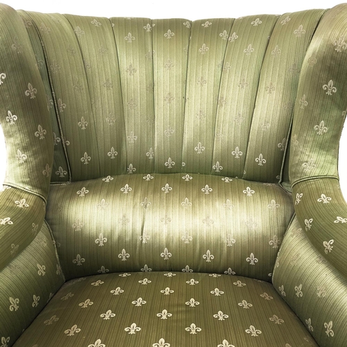 131 - WING ARMCHAIR, Victorian walnut in green fleur de lis upholstery on brass castors.