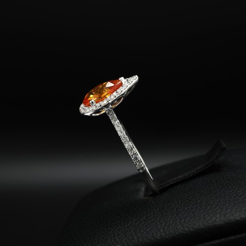 26 - 18ct white gold ring set with a pear shaped orange sapphire surrounded by RBC diamonds, with further... 