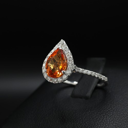 26 - 18ct white gold ring set with a pear shaped orange sapphire surrounded by RBC diamonds, with further... 