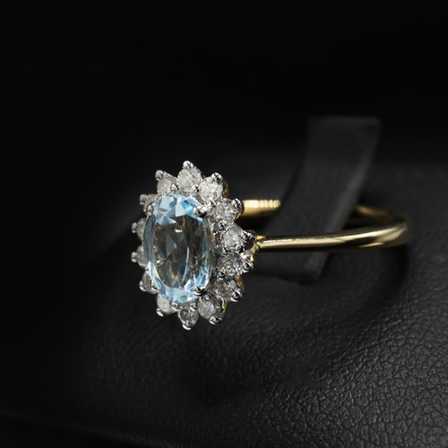 29 - 9ct yellow and white gold oval-cut blue topaz and RBC diamond cluster ring. Topaz 0.94ct. Diamonds 0... 