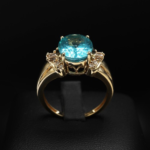 20 - 14ct yellow gold paraibe apatite and diamond dress ring. Oval-cut apatite 3.40ct. Baguette and round... 