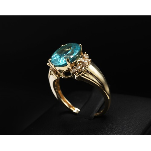 20 - 14ct yellow gold paraibe apatite and diamond dress ring. Oval-cut apatite 3.40ct. Baguette and round... 