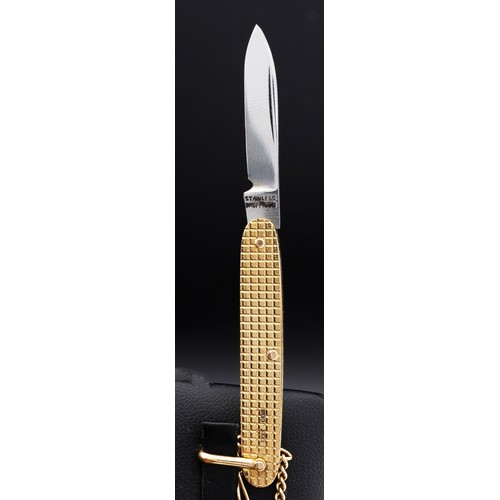 61 - A 9CT GOLD CASED PENKNIFE, with engine turned decoration, inscribed initials, fitted on a 9ct rose g... 