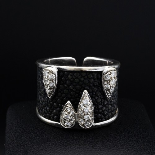 84 - AN 18CT WHITE GOLD SHAGREEN AND DIAMOND ENCRUSTED CUFF BANGLE, with torpedo shaped motifs encrusted ... 