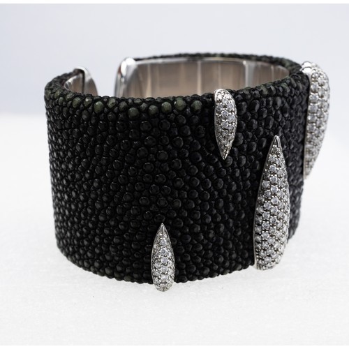 84 - AN 18CT WHITE GOLD SHAGREEN AND DIAMOND ENCRUSTED CUFF BANGLE, with torpedo shaped motifs encrusted ... 