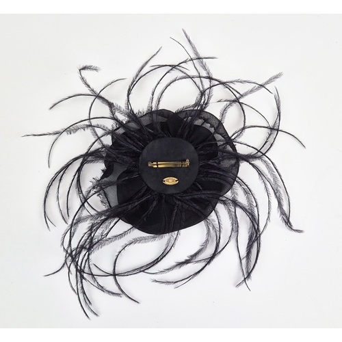 11 - CHANEL BROOCH, iconic black silk camellia with raw hem, ostrich feather at base, gold tone safety pi... 